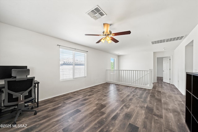 home office with dark wood-style floors, visible vents, and ceiling fan