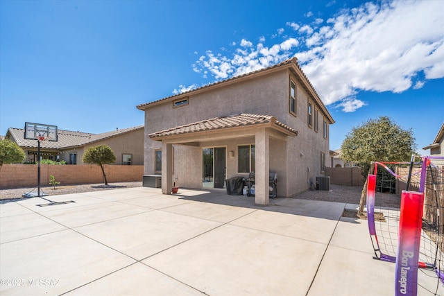 rear view of property featuring a playground, stucco siding, cooling unit, a fenced backyard, and a patio area