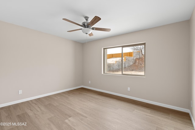 empty room with baseboards, light wood-style flooring, and a ceiling fan