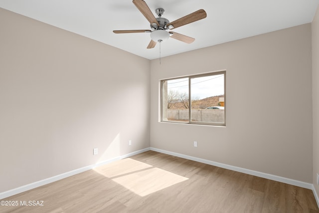 empty room with light wood-style flooring, baseboards, and ceiling fan