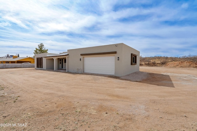 view of front of home with stucco siding and a garage