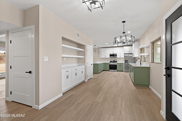 kitchen featuring a notable chandelier, appliances with stainless steel finishes, green cabinets, and open shelves