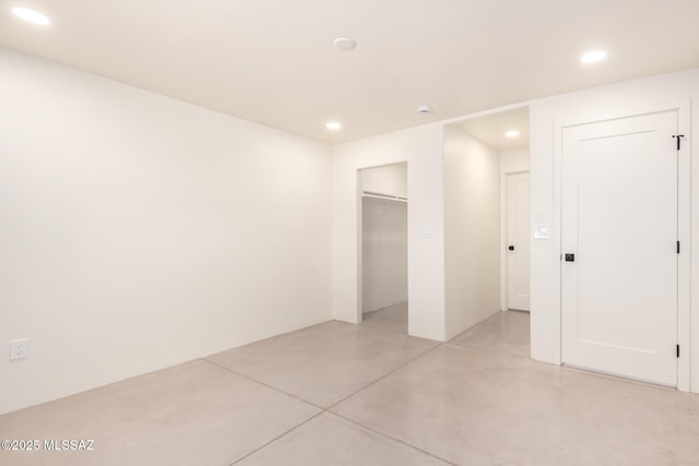 unfurnished bedroom with recessed lighting and concrete flooring