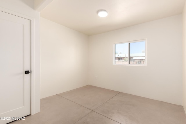 unfurnished room with concrete flooring