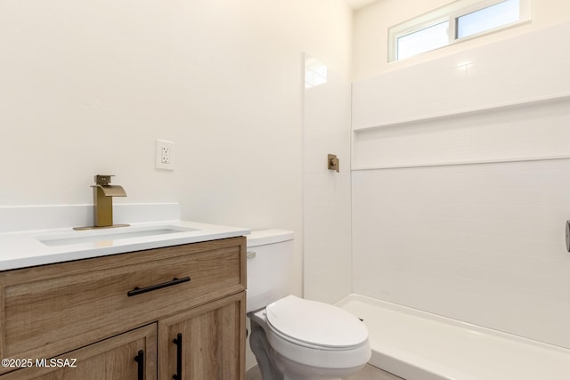 full bath featuring tiled shower, toilet, and vanity