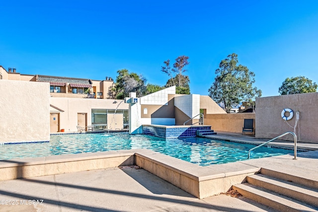 pool with a patio and fence