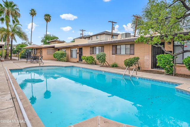 view of pool with a patio area, a fenced in pool, and fence