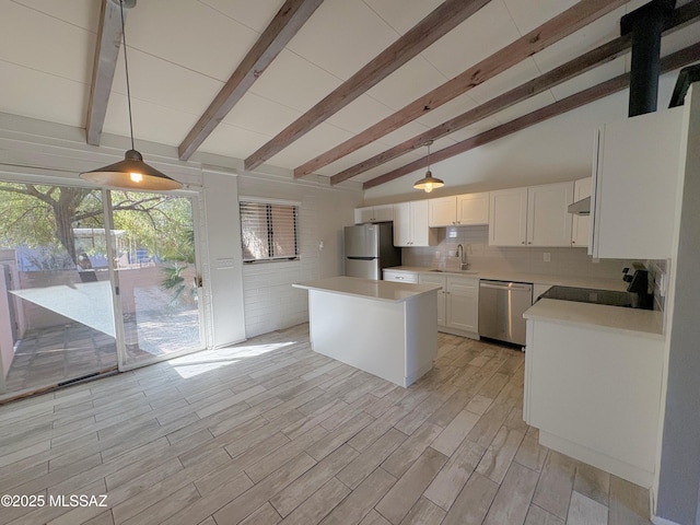 kitchen with tasteful backsplash, lofted ceiling with beams, white cabinets, stainless steel appliances, and a sink