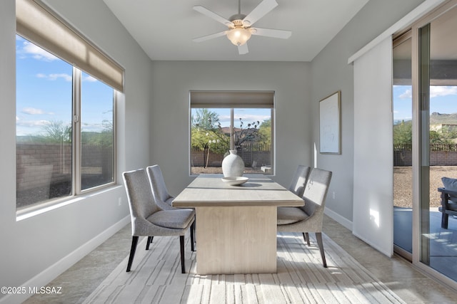 dining space with baseboards and a ceiling fan