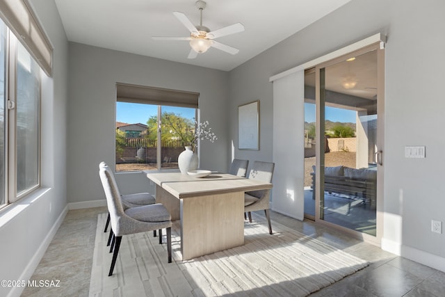 dining area with baseboards and ceiling fan