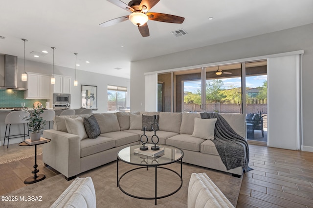 living area featuring recessed lighting, visible vents, light wood finished floors, and ceiling fan