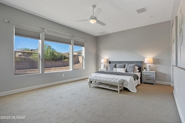 bedroom with baseboards, visible vents, and light carpet