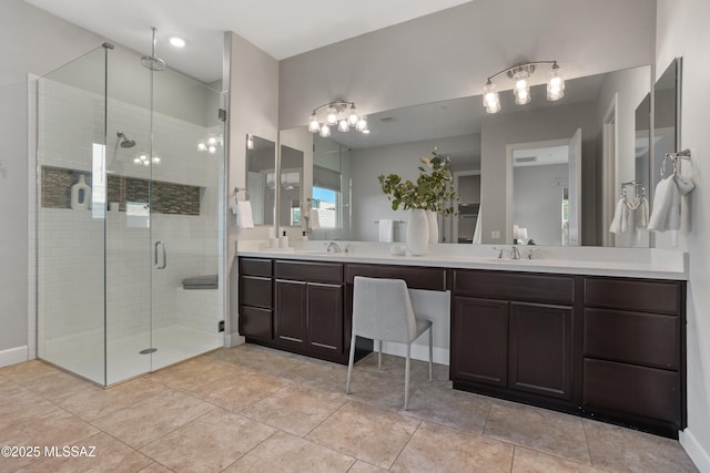 full bathroom with double vanity, a stall shower, tile patterned floors, and a sink