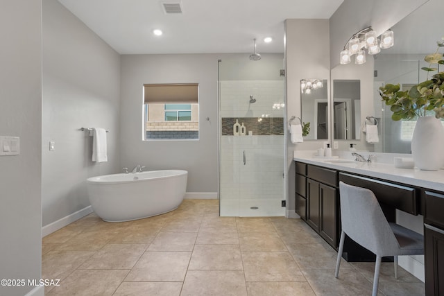 bathroom featuring vanity, baseboards, visible vents, a stall shower, and a freestanding bath