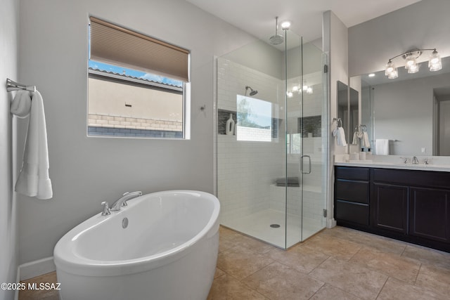 full bath with a shower stall, baseboards, a freestanding tub, tile patterned floors, and vanity