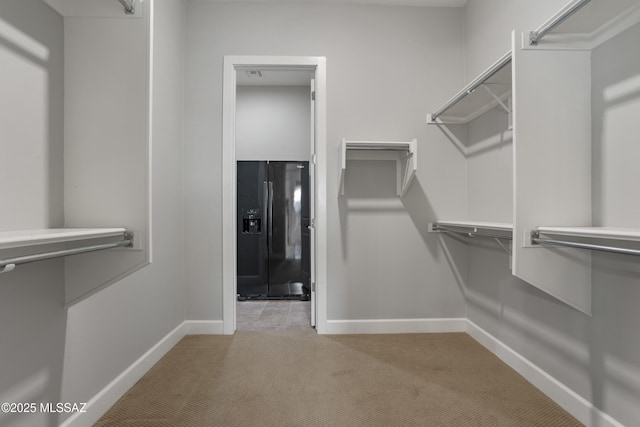 walk in closet featuring light carpet