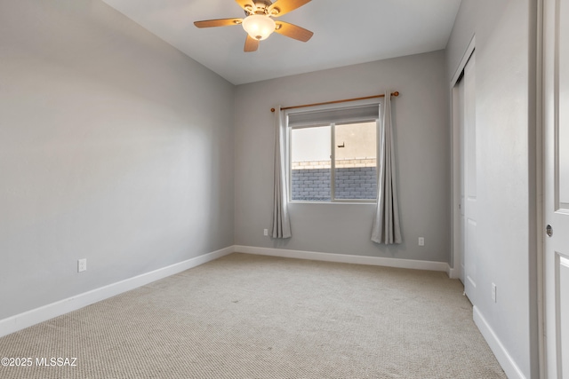 unfurnished bedroom featuring baseboards, light carpet, and a ceiling fan