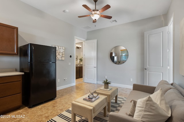 living room with visible vents, baseboards, and ceiling fan