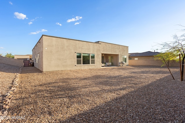 back of house featuring a patio, a fenced backyard, and stucco siding