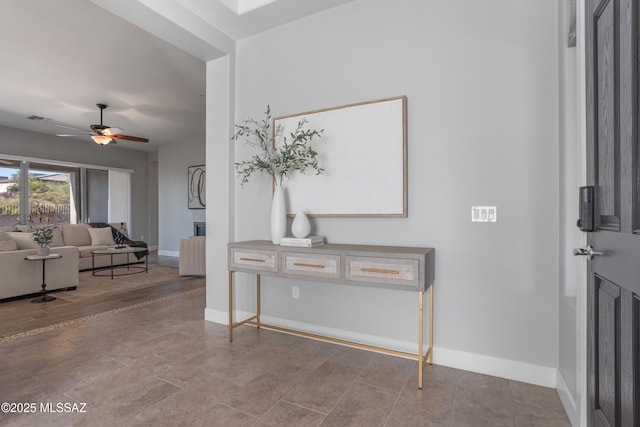 foyer entrance featuring visible vents, baseboards, wood finished floors, and a ceiling fan