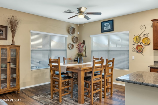 dining space with dark wood-style floors, baseboards, and ceiling fan