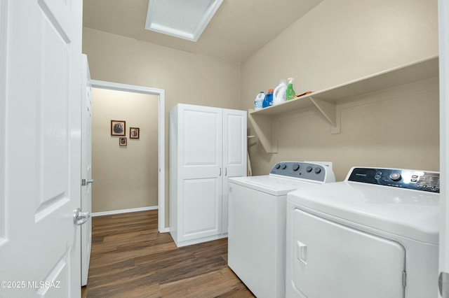 clothes washing area featuring baseboards, washer and clothes dryer, attic access, cabinet space, and dark wood-style flooring