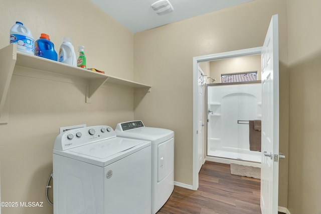 clothes washing area featuring washer and dryer, baseboards, dark wood-style floors, and laundry area