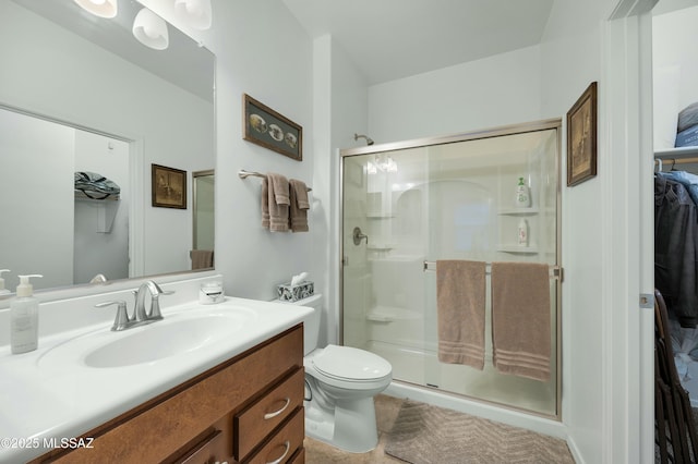 full bath featuring vanity, a spacious closet, toilet, and a stall shower