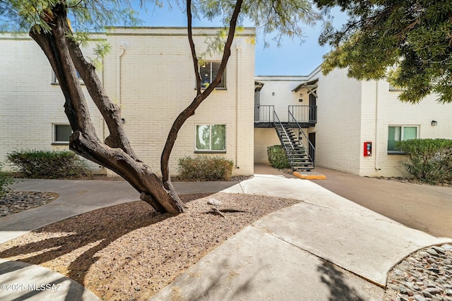 view of home's exterior featuring stairs and brick siding