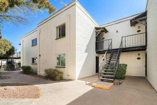 view of home's exterior with stairs and brick siding