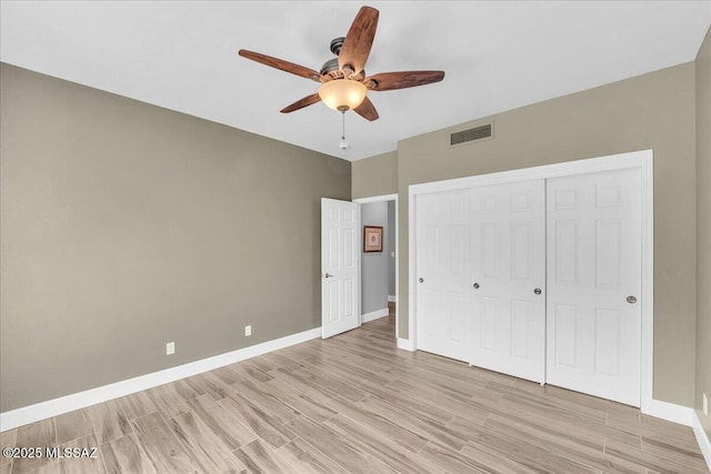 unfurnished bedroom featuring visible vents, light wood-style flooring, a ceiling fan, a closet, and baseboards