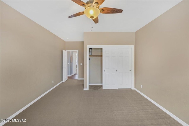 unfurnished bedroom with ceiling fan, carpet, baseboards, lofted ceiling, and a closet