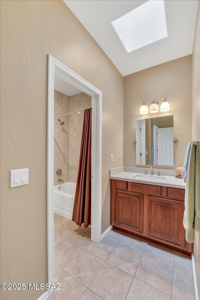 full bath with baseboards, shower / bath combination with curtain, vanity, a skylight, and tile patterned flooring