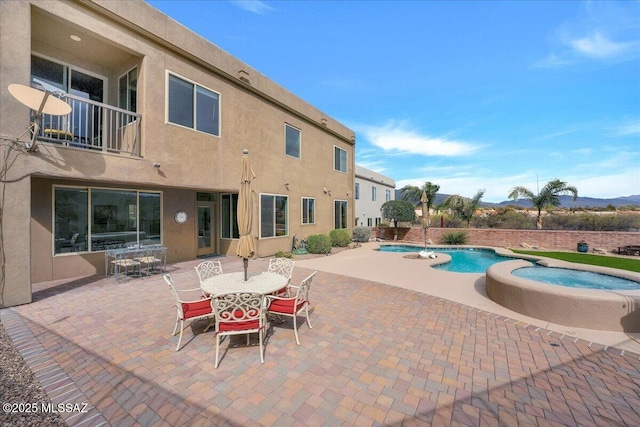 view of swimming pool featuring an in ground hot tub, outdoor dining area, a fenced in pool, and a patio