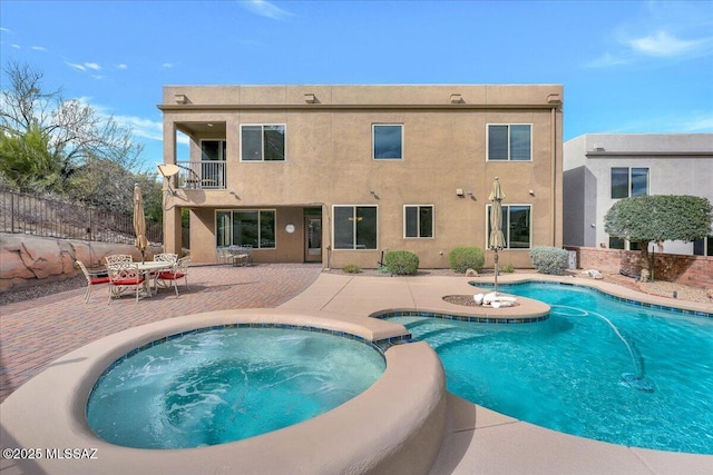 view of pool featuring a patio area, a pool with connected hot tub, and fence