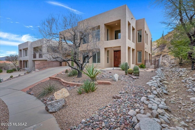 adobe home with stucco siding and concrete driveway