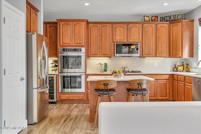 kitchen featuring light countertops, light wood-type flooring, recessed lighting, stainless steel appliances, and a kitchen island