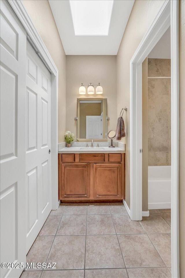 full bathroom with  shower combination, baseboards, tile patterned flooring, and vanity