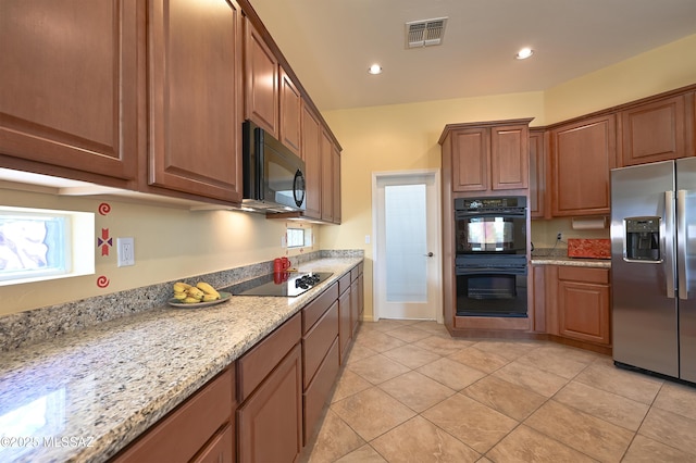 kitchen with black appliances, recessed lighting, light stone countertops, and visible vents