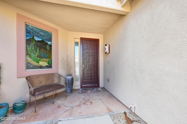 doorway to property featuring stucco siding