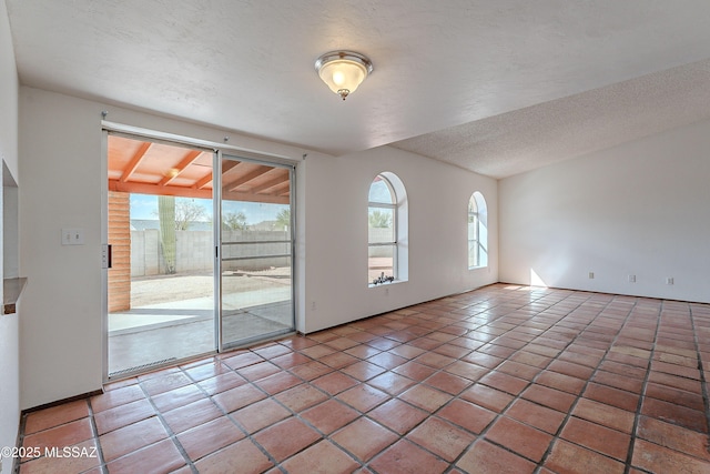 tiled spare room with a textured ceiling