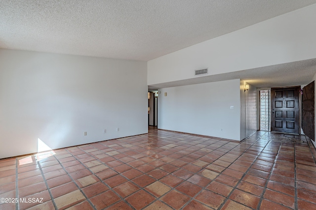 tiled empty room featuring visible vents and a textured ceiling