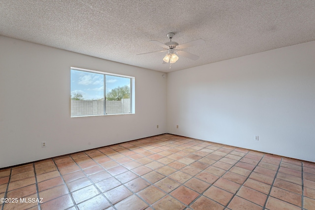 spare room with light tile patterned floors, a textured ceiling, and ceiling fan