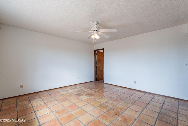 spare room with light tile patterned floors, a textured ceiling, and ceiling fan