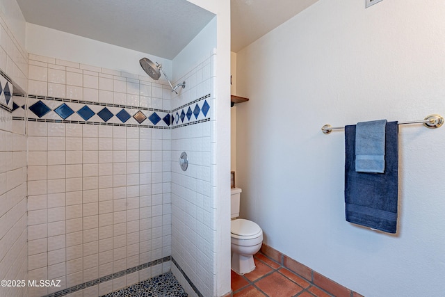 full bathroom featuring tile patterned floors, baseboards, tiled shower, and toilet