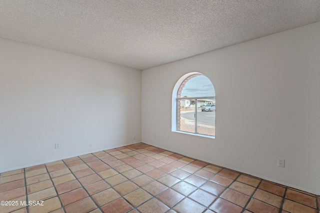 unfurnished room featuring light tile patterned floors and a textured ceiling