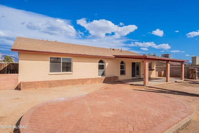 rear view of property with a patio area, stucco siding, central AC, and fence