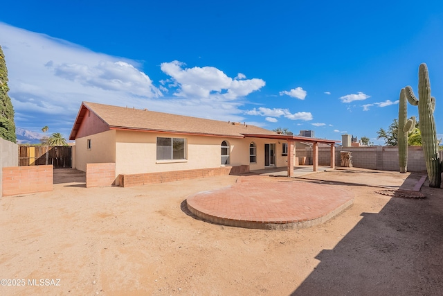 back of house with stucco siding, a fenced backyard, and a patio area