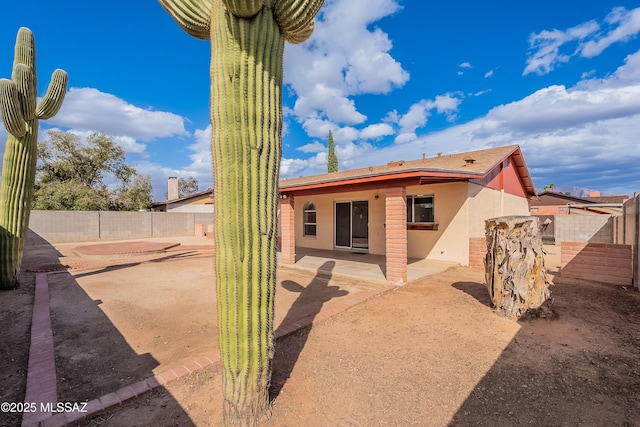 rear view of house featuring a patio, a fenced backyard, and stucco siding