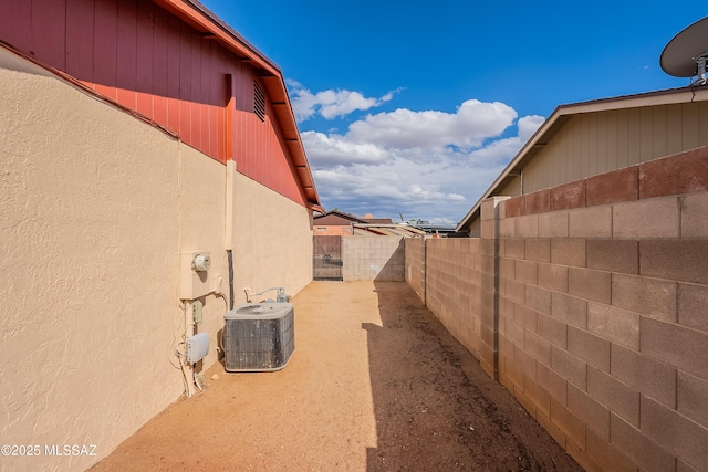 view of side of property with central air condition unit and a fenced backyard